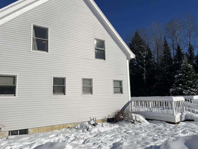 snow covered property with a wooden deck