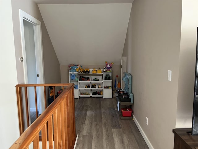 additional living space featuring vaulted ceiling, dark wood finished floors, and baseboards