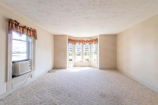 carpeted empty room featuring a textured ceiling and cooling unit