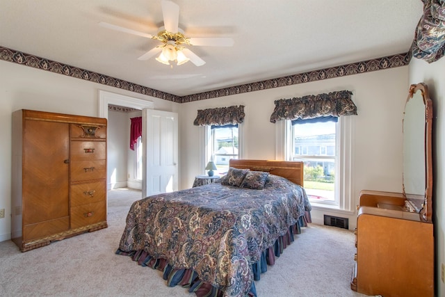 carpeted bedroom featuring multiple windows and ceiling fan