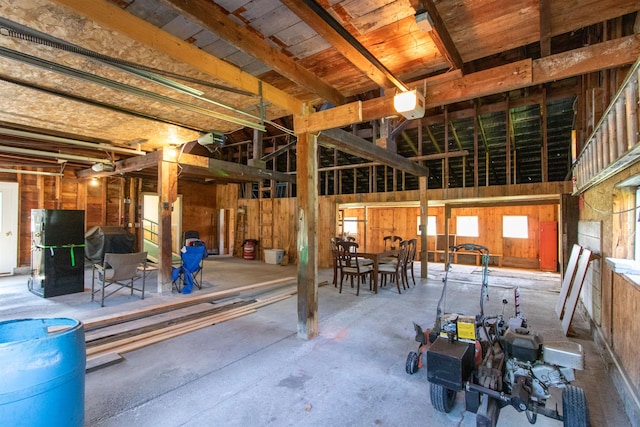 miscellaneous room featuring wooden walls and concrete floors