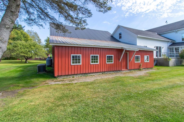 6694 Vt Route 100, Troy, VT 05859 - rear view of property with a yard, metal roof, board and batten siding, central air condition unit, and an outbuilding