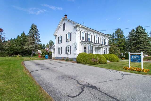 6694 Vt Route 100, Troy, VT 05859 - view of front facade with a chimney, driveway, and a front lawn