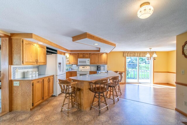 6694 Vt Route 100, Troy, VT 05859 - kitchen with a textured ceiling, an inviting chandelier, white appliances, and light floors
