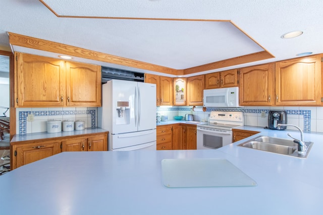 kitchen featuring white appliances, sink, and tasteful backsplash