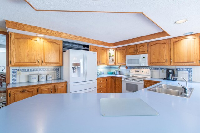 6694 Vt Route 100, Troy, VT 05859 - kitchen featuring white appliances, tasteful backsplash, light countertops, a sink, and brown cabinets