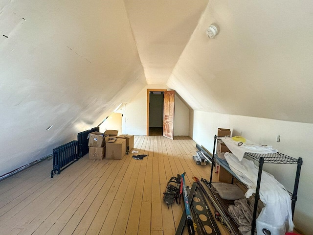 additional living space with hardwood / wood-style flooring and lofted ceiling