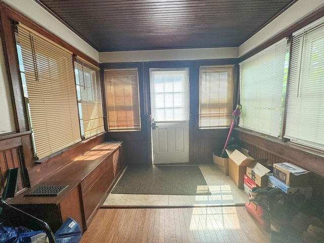 interior space with wood ceiling, wooden walls, and light hardwood / wood-style floors