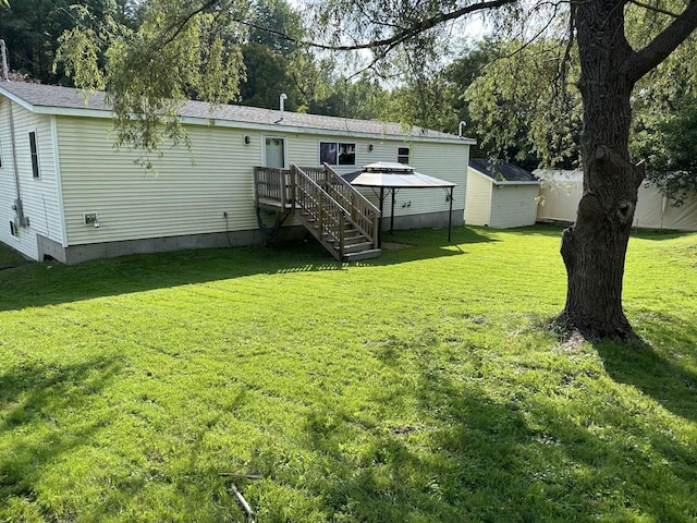 rear view of house featuring a storage unit, a lawn, and a deck