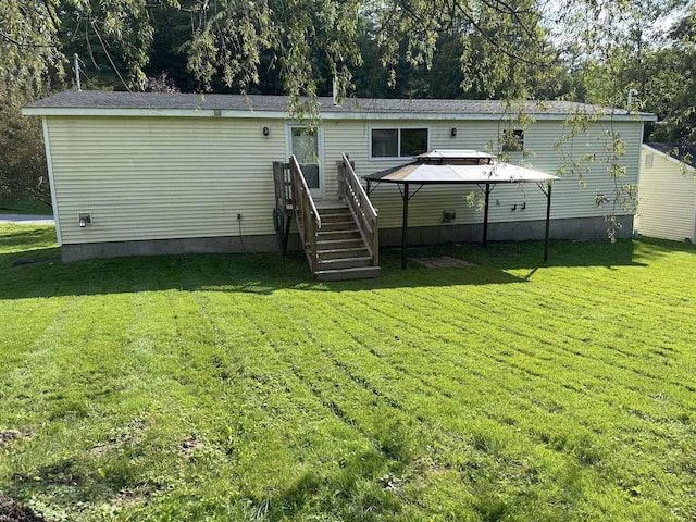 back of house with a yard and a gazebo