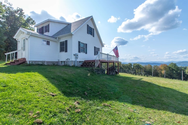 view of side of home featuring a yard and a deck