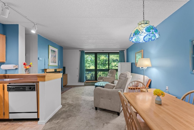 kitchen with dishwasher, light colored carpet, rail lighting, pendant lighting, and a textured ceiling