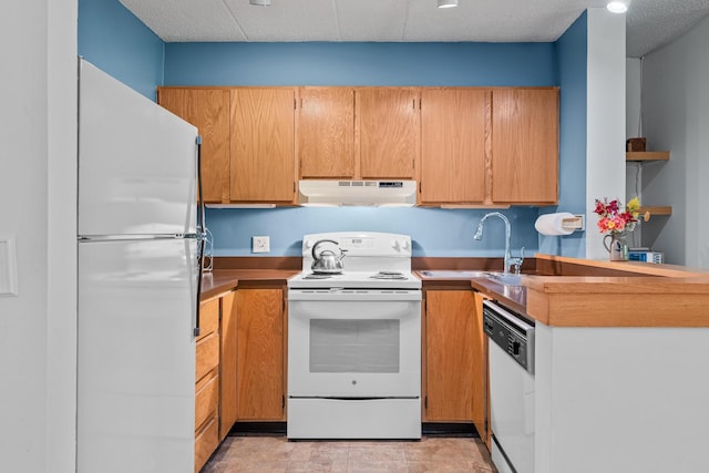 kitchen featuring sink, light tile patterned floors, and white appliances