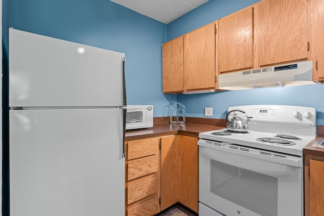 kitchen featuring a textured ceiling and white appliances