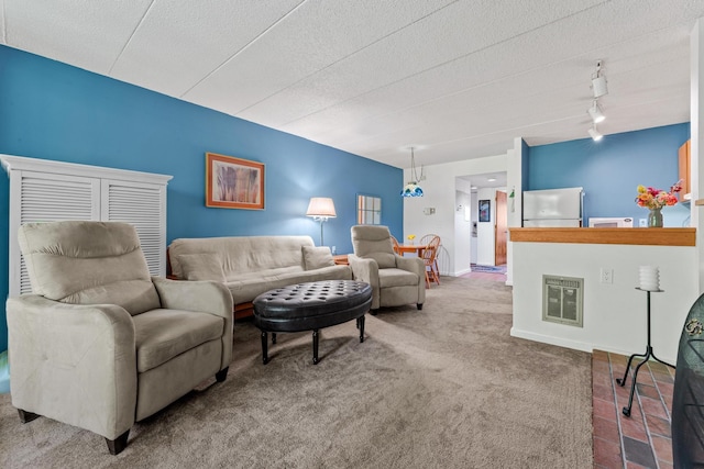 carpeted living room featuring a textured ceiling, rail lighting, and heating unit