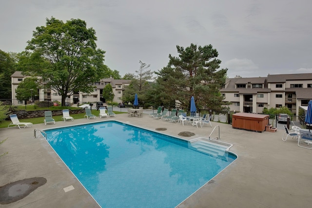 view of pool featuring a patio and a hot tub