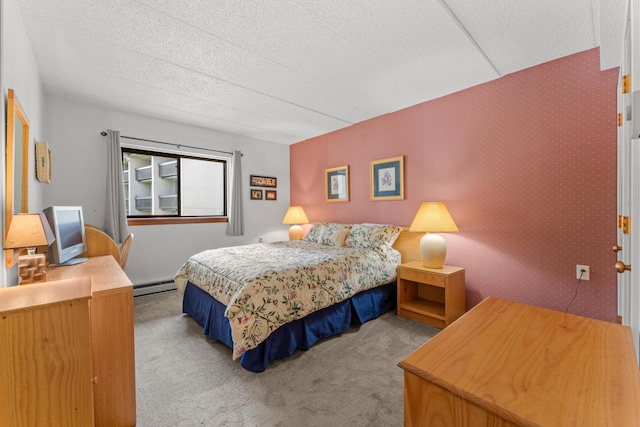 bedroom featuring a baseboard radiator, light colored carpet, and a textured ceiling