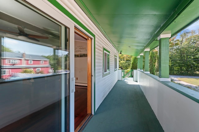 balcony with a baseboard radiator, ceiling fan, and a porch