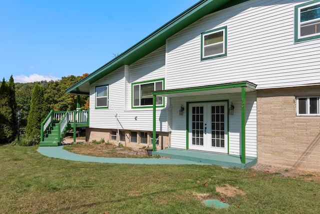 back of house featuring a yard and french doors