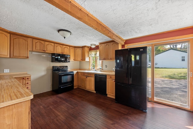 kitchen featuring black appliances, a wealth of natural light, and dark wood-type flooring