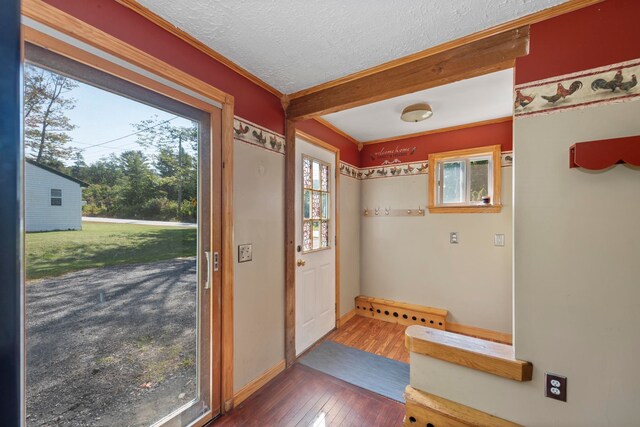 entryway featuring a textured ceiling, ornamental molding, and dark hardwood / wood-style flooring