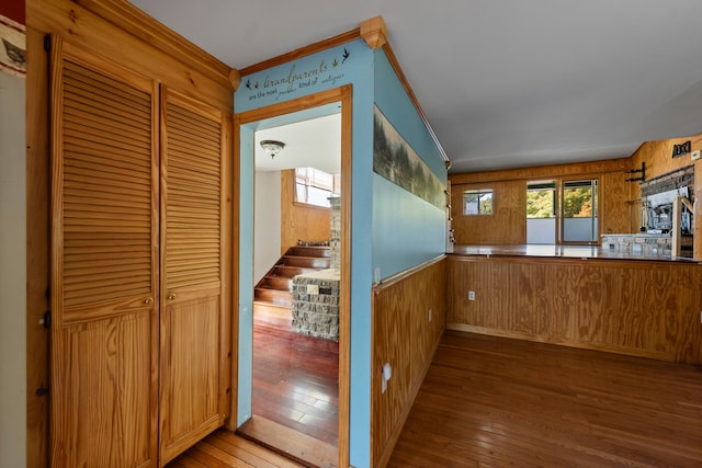 interior space with crown molding, hardwood / wood-style flooring, and wood walls