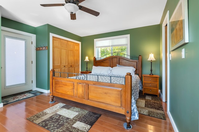bedroom with wood finished floors, a closet, a ceiling fan, and baseboards