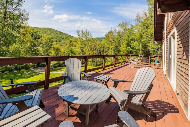 wooden terrace featuring a forest view