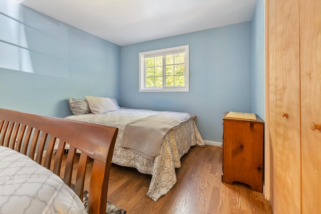 bedroom with baseboards and wood finished floors