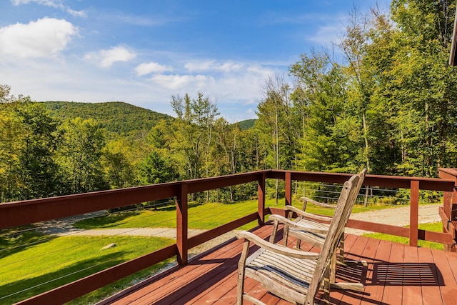 wooden terrace with a view of trees and a yard