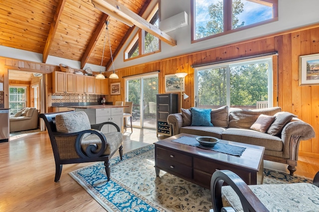 living room featuring wooden walls, light wood-type flooring, and high vaulted ceiling