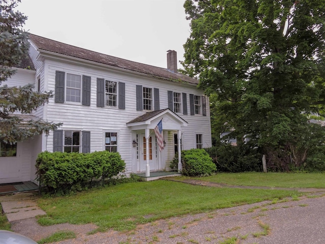 colonial house featuring a front lawn