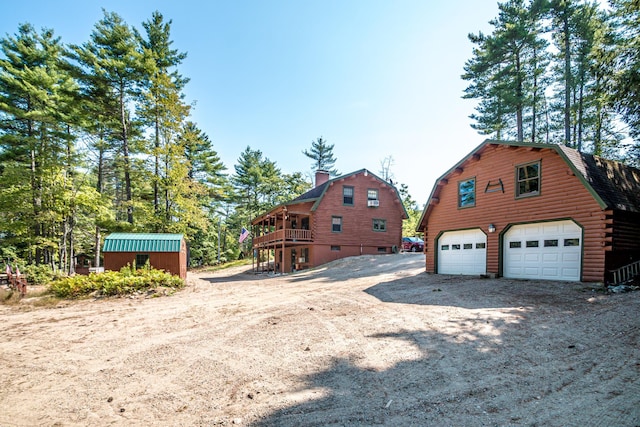 359 Gold Coast Dr, Wakefield, NH 03830 - view of property exterior featuring a gambrel roof, an outdoor structure, a garage, a chimney, and log siding