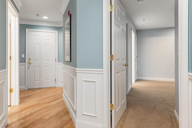 hallway featuring light carpet and crown molding