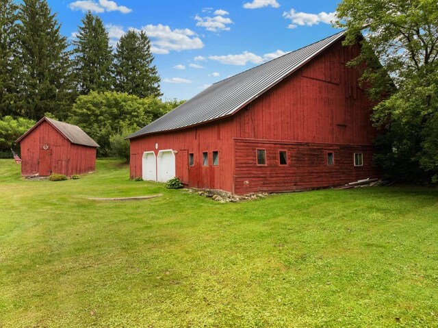 view of home's exterior with a lawn and an outbuilding