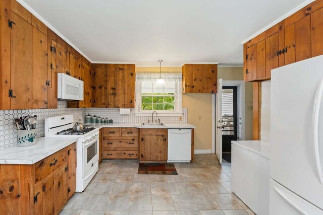 kitchen featuring hanging light fixtures, decorative backsplash, white appliances, light tile patterned floors, and crown molding