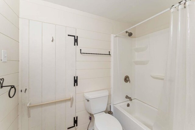 bathroom featuring shower / bath combination with curtain and toilet