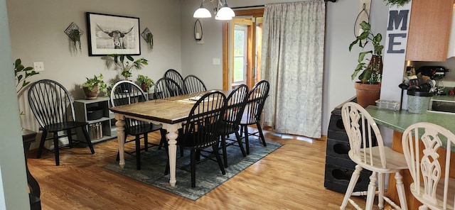 dining area featuring wood-type flooring and a notable chandelier