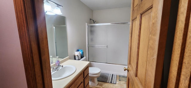 full bathroom with vanity, enclosed tub / shower combo, and toilet