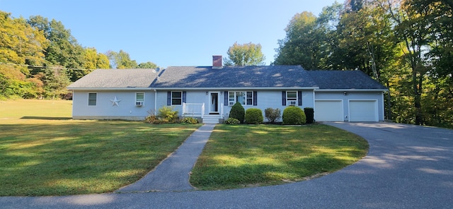 single story home featuring a front lawn and a garage