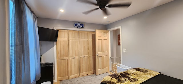 bedroom featuring a closet, ceiling fan, and light colored carpet