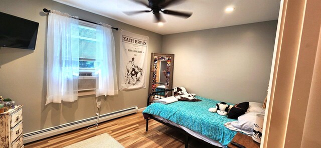 bedroom featuring a closet, light hardwood / wood-style floors, a baseboard radiator, and ceiling fan