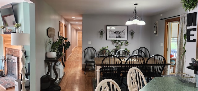 dining area featuring wood-type flooring and a notable chandelier