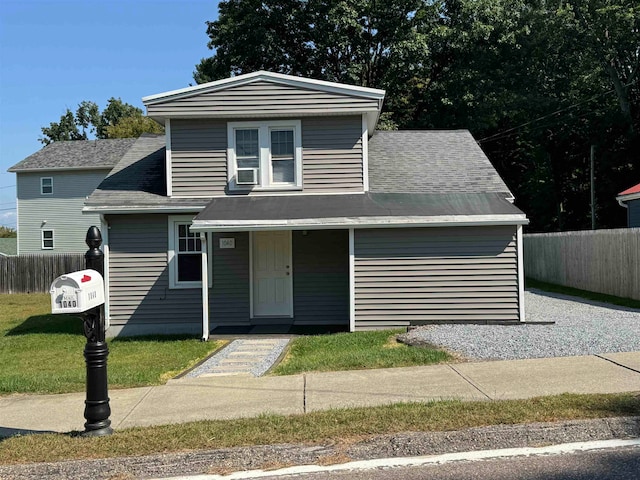 view of front of property with cooling unit, a front lawn, and covered porch