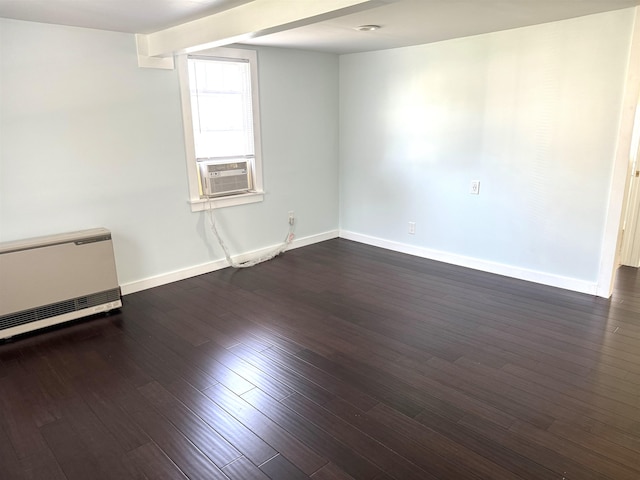 unfurnished room featuring cooling unit, dark hardwood / wood-style floors, and heating unit