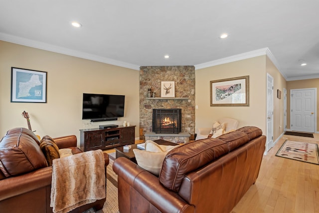 living room featuring crown molding, a fireplace, and light hardwood / wood-style flooring