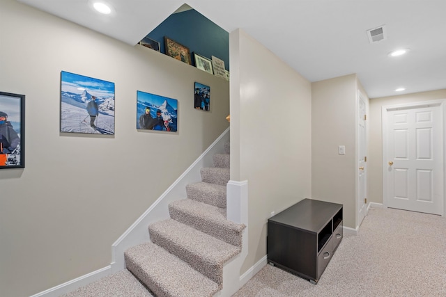 staircase featuring carpet