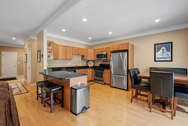 kitchen with appliances with stainless steel finishes, kitchen peninsula, a breakfast bar area, crown molding, and light hardwood / wood-style flooring