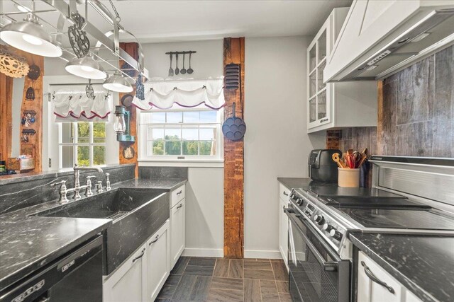 kitchen featuring white cabinetry, stainless steel range with electric stovetop, dishwasher, exhaust hood, and dark stone counters