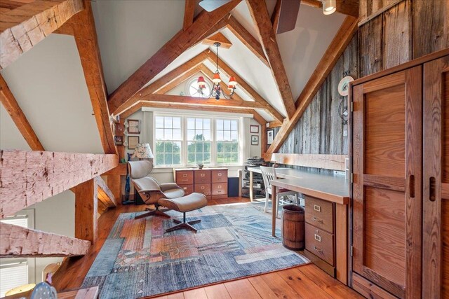 living area featuring lofted ceiling with beams and light hardwood / wood-style flooring